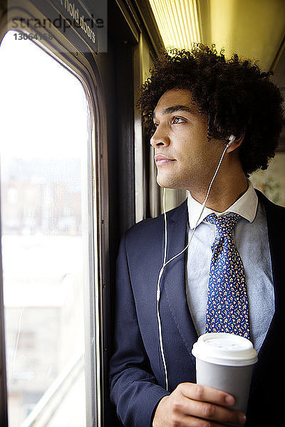 Mann schaut weg  während er im Zug reist