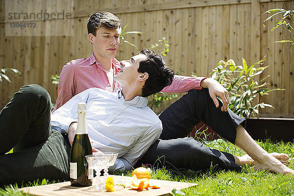 Schwule Männer  die sich beim Entspannen auf dem Spielfeld im Hinterhof anschauen