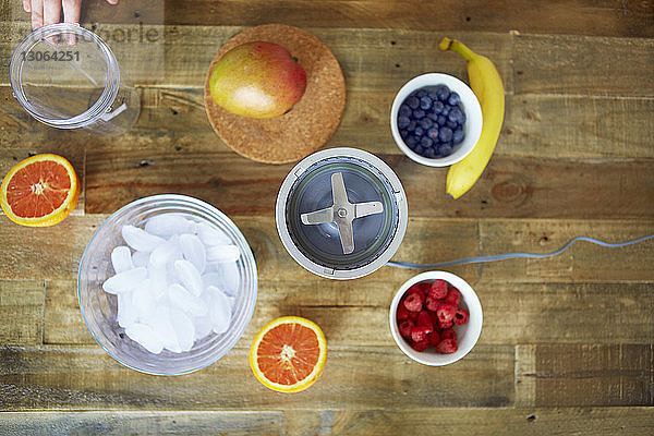 Draufsicht auf den Mixer mit Früchten und Behältern auf dem Tisch
