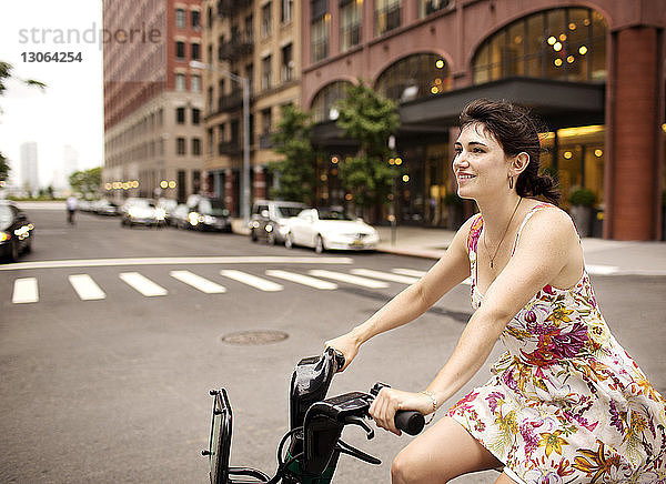 Glückliche Fahrrad fahrende Frau in der Stadt