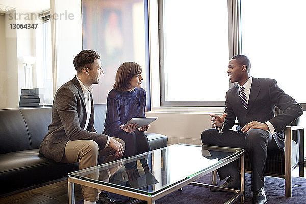 Geschäftsleute diskutieren  während sie im Büro sitzen