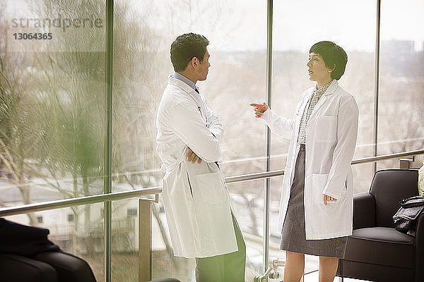 Ärzte diskutieren  während sie im Krankenhaus am Fenster stehen