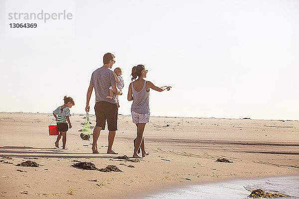 Familie in voller Länge am Strand bei klarem Himmel
