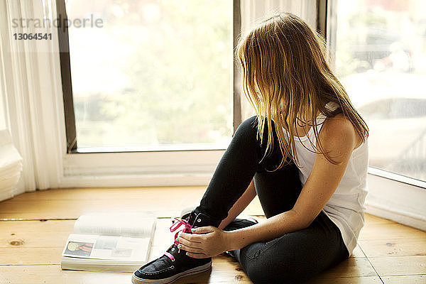 Mädchen lernt  während sie zu Hause am Fenster sitzt