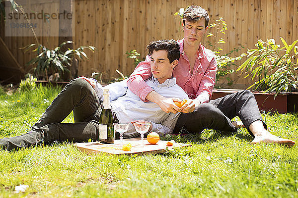 Schwules Paar entspannt sich auf dem Feld im Hinterhof