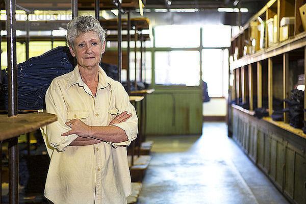 Porträt eines Arbeiters  der in einem Fabriklager steht