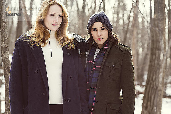 Porträt von Freunden  die im Winter im Wald stehen