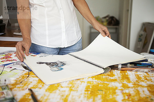 Beschnittenes Bild einer Frau  die sich im Kunstatelier Skizzen ansieht