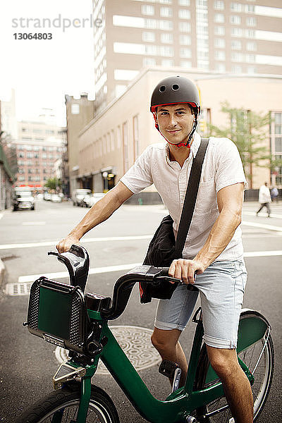 Porträt eines Mannes mit Fahrrad auf der Straße