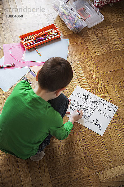 Hochwinkelansicht eines Jungen  der zu Hause zeichnet