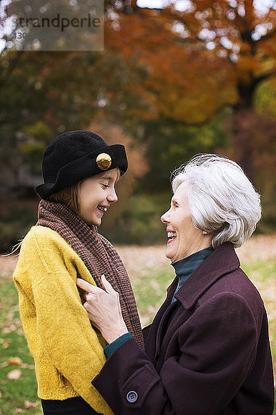 Großmutter und Enkelin sehen sich im Park an und lächeln
