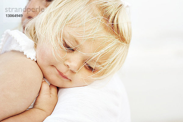 Süßes Mädchen lehnt sich an die Schulter der Mutter