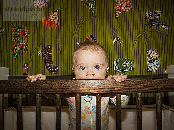 Porträt eines kleinen Jungen im Kinderbett zu Hause