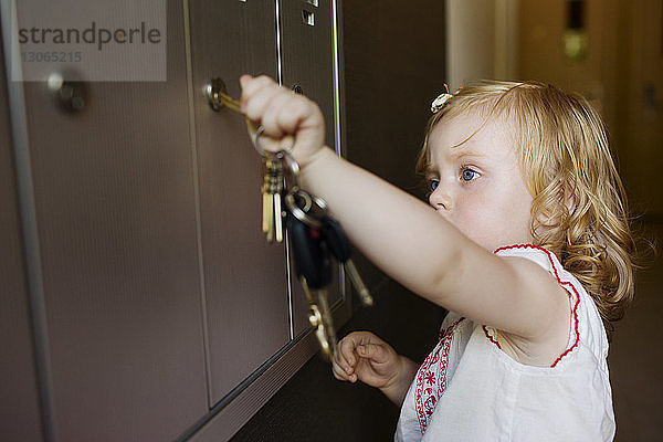 Baby-Mädchen öffnet Spind zu Hause