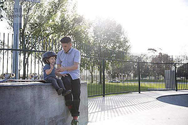 Vater und Sohn sitzen im Skateboard-Park