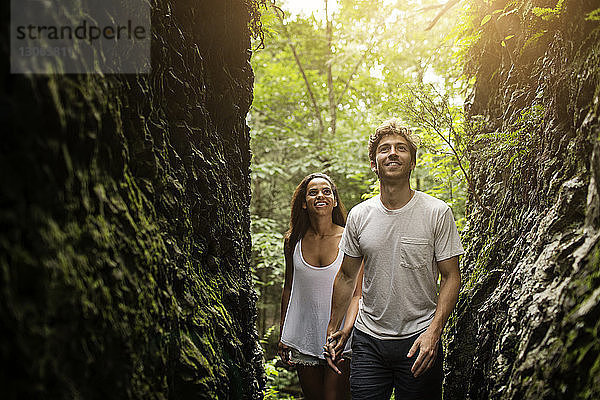 Ehepaar schaut auf  während es im Wald spazieren geht