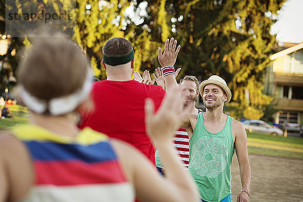 Fröhliche Freunde  die beim Gehen auf dem Spielfeld ein High Five geben