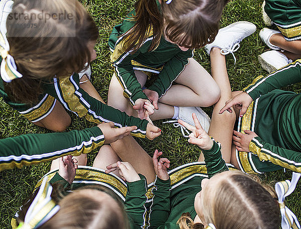 Hochwinkelansicht von Cheerleadern  die auf dem Spielfeld klatschen