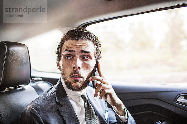 Geschäftsmann telefoniert während der Fahrt im Auto