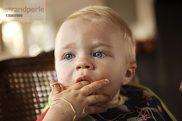 Kleiner Junge schaut weg  während er Nudeln isst