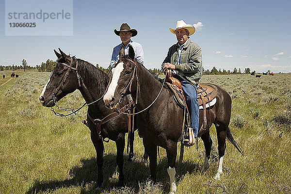 Porträt von Männern zu Pferd auf dem Feld sitzend