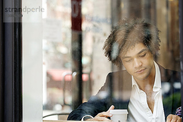 Mann schaut weg  während er im Café sitzt