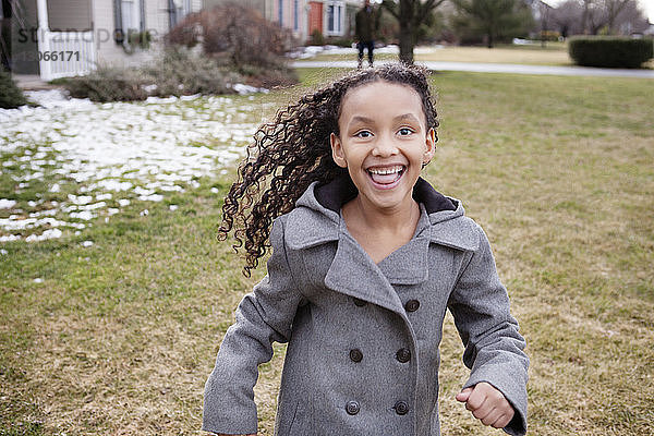 Porträt eines glücklichen Mädchens  das im Hinterhof läuft
