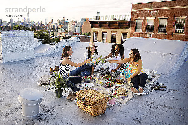 Freunde stoßen bei einer Party auf der Terrasse des Gebäudes an