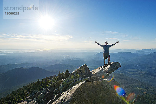 Mann steht auf Berg gegen Himmel