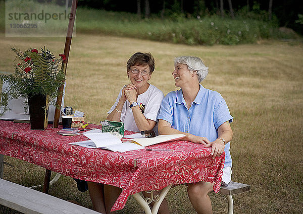 Freund spricht  während er am Picknicktisch sitzt