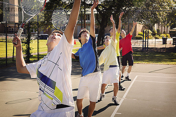 In der Reihe stehende Spieler spielen Tennis auf dem Platz