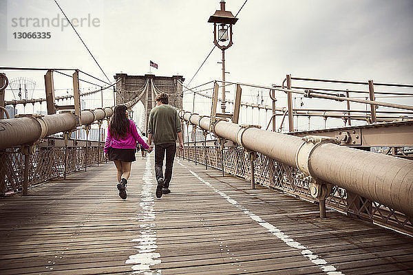 Rückansicht eines Ehepaares auf der Brooklyn Bridge in der Stadt bei klarem Himmel