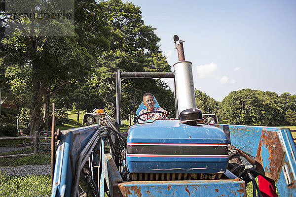 Junge schaut weg  während er im Traktor sitzt