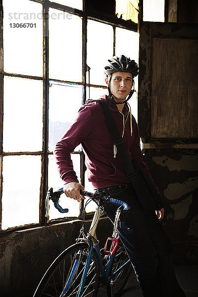 Porträt eines Mannes  der auf einem Fahrrad sitzt