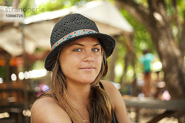 Porträt einer Frau mit Hut  die sich am Urlaubsort erfreut