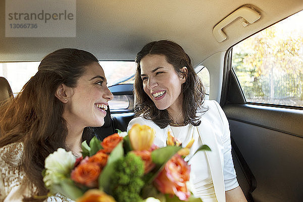 Glückliches lesbisches Hochzeitspaar im Auto