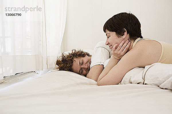 Lächelndes Paar entspannt zu Hause im Bett
