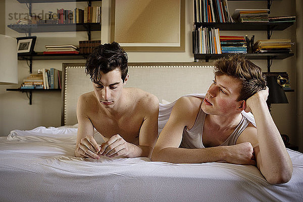 Schwules Paar entspannt zu Hause im Bett