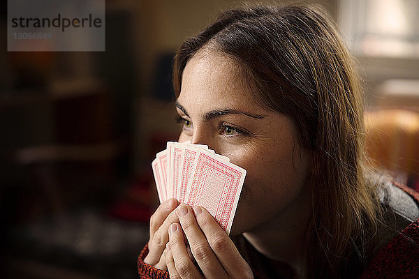 Nahaufnahme einer Frau  die beim Spielen zu Hause Karten hält