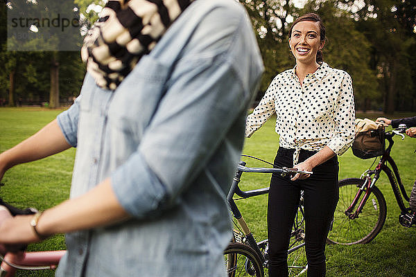 Freunde mit Fahrrädern zu Fuß auf dem Feld im Central Park