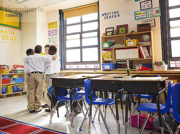 Jungen diskutieren im Stehen im Klassenzimmer