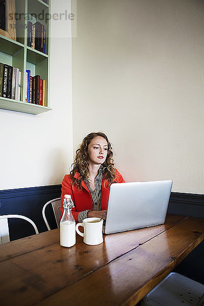 Frau benutzt Laptop-Computer  während sie im Café sitzt
