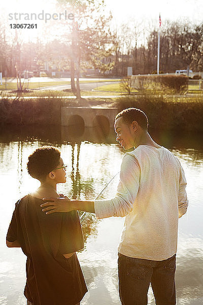 Vater spricht mit Sohn beim Angeln im See