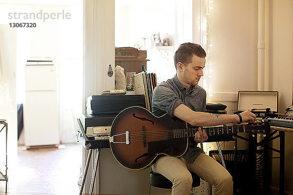 Mann spielt zu Hause Gitarre