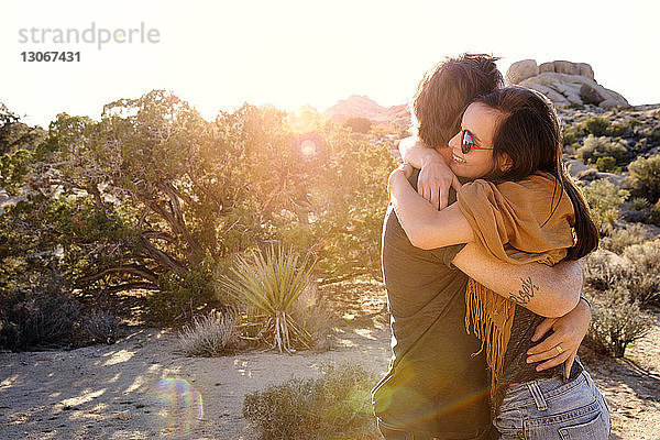 Glückliches Paar umarmt sich an einem sonnigen Tag vor klarem Himmel