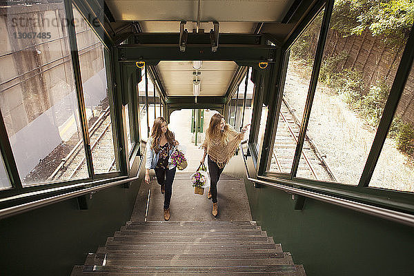 Hochwinkelansicht von Frauen beim Treppensteigen am Bahnhof