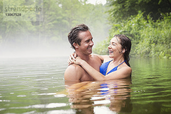 Glückliches Paar schwimmt im See
