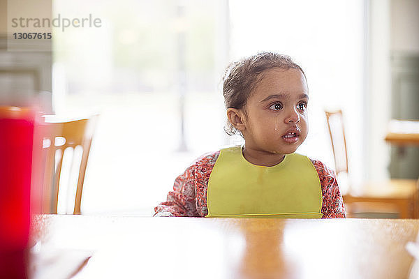 Mädchen weint  während sie im Restaurant am Tisch sitzt