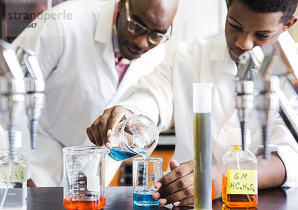 Lehrer betrachtet Schüler beim wissenschaftlichen Experiment an der High School