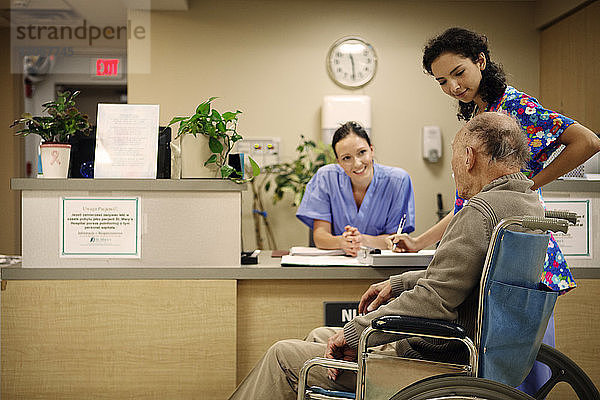 Ärztinnen im Gespräch mit älteren Patienten im Krankenhaus